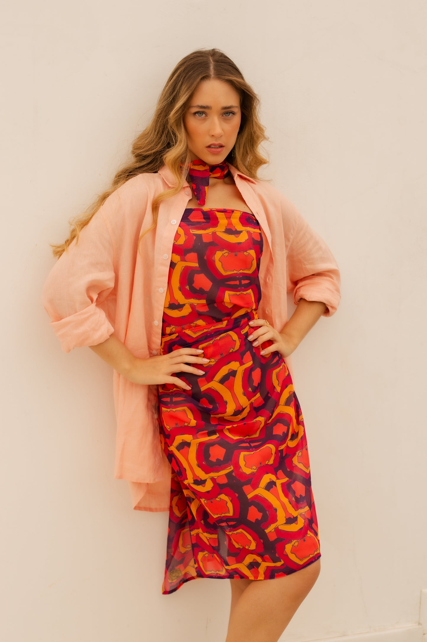 Modelo vestindo o Pareo Yoga Sutra Laranja/Roxo, destacando a vibrante combinação de cores e estampa moderna, e a camisa de linho laranja por cima.