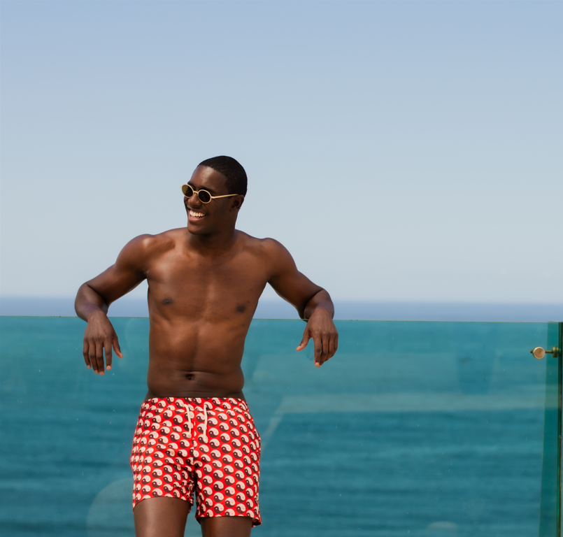 Modelo vestindo Shorts Yin and Out Vermelho com estampa yin-yang, mostrando ajuste confortável e material leve.