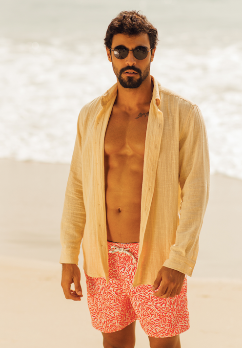 Camisa de linho areia concha combinada com shorts vermelhos, ideal para praia.