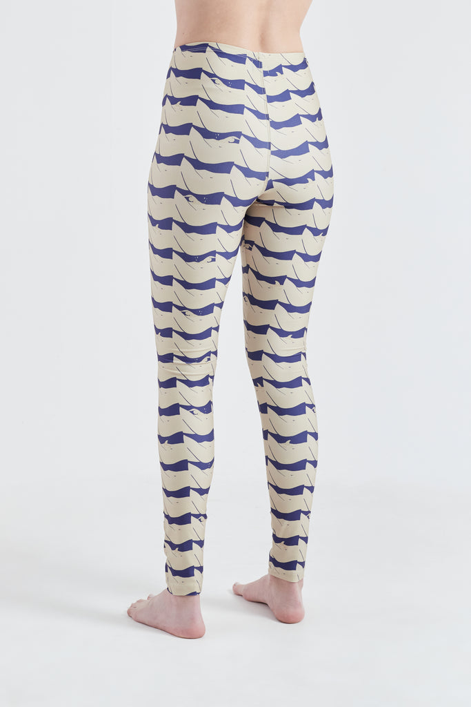 Modelo usando calça legging feminina azul/creme em lycra com estampa Onda.