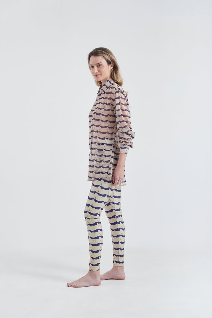 Modelo usando calça legging feminina azul/creme em lycra com estampa Onda.
