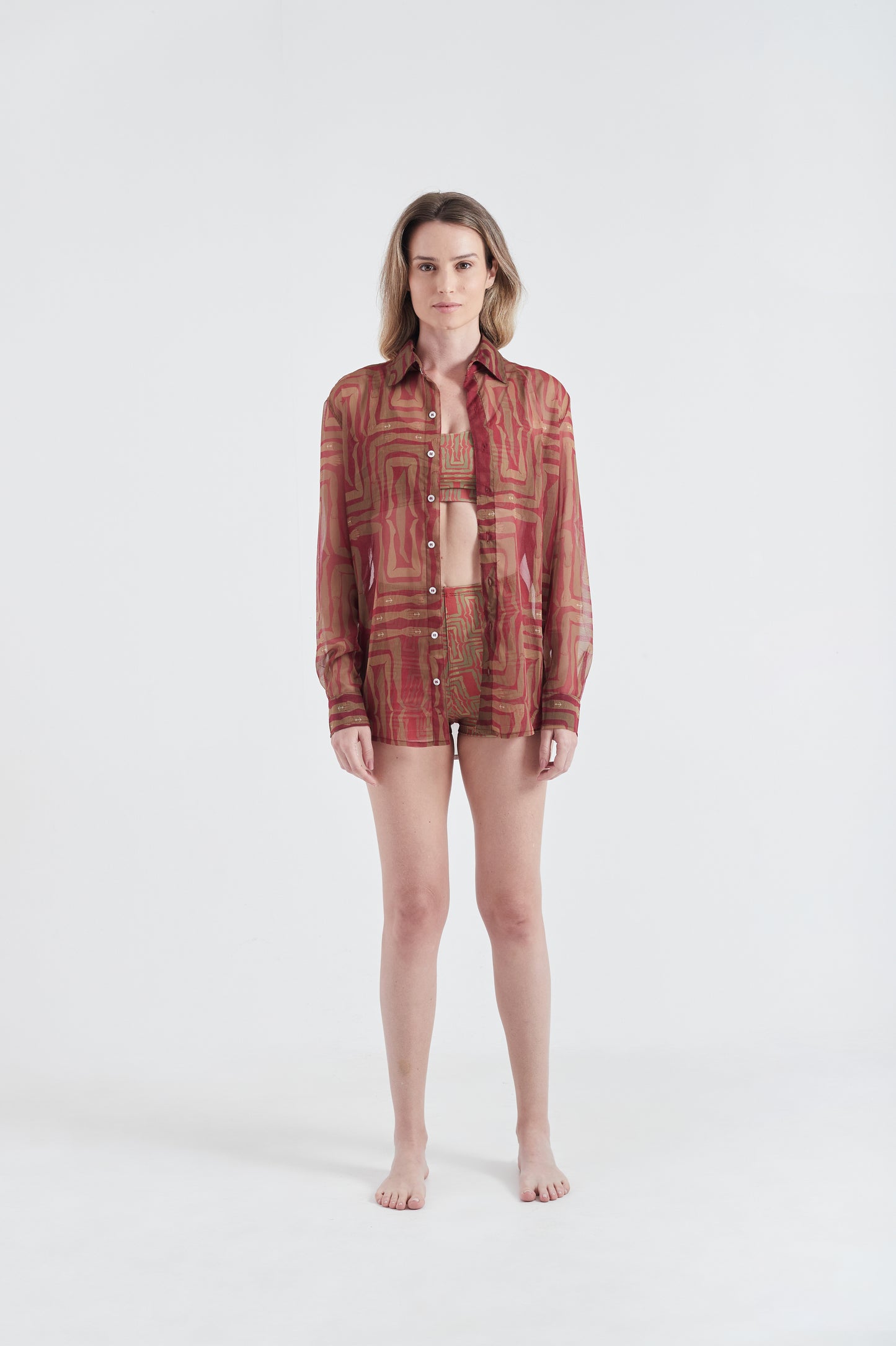 Modelo usando a Camisa Vermelho/Amarelo com estampa Mão na Perna, feita em tule.