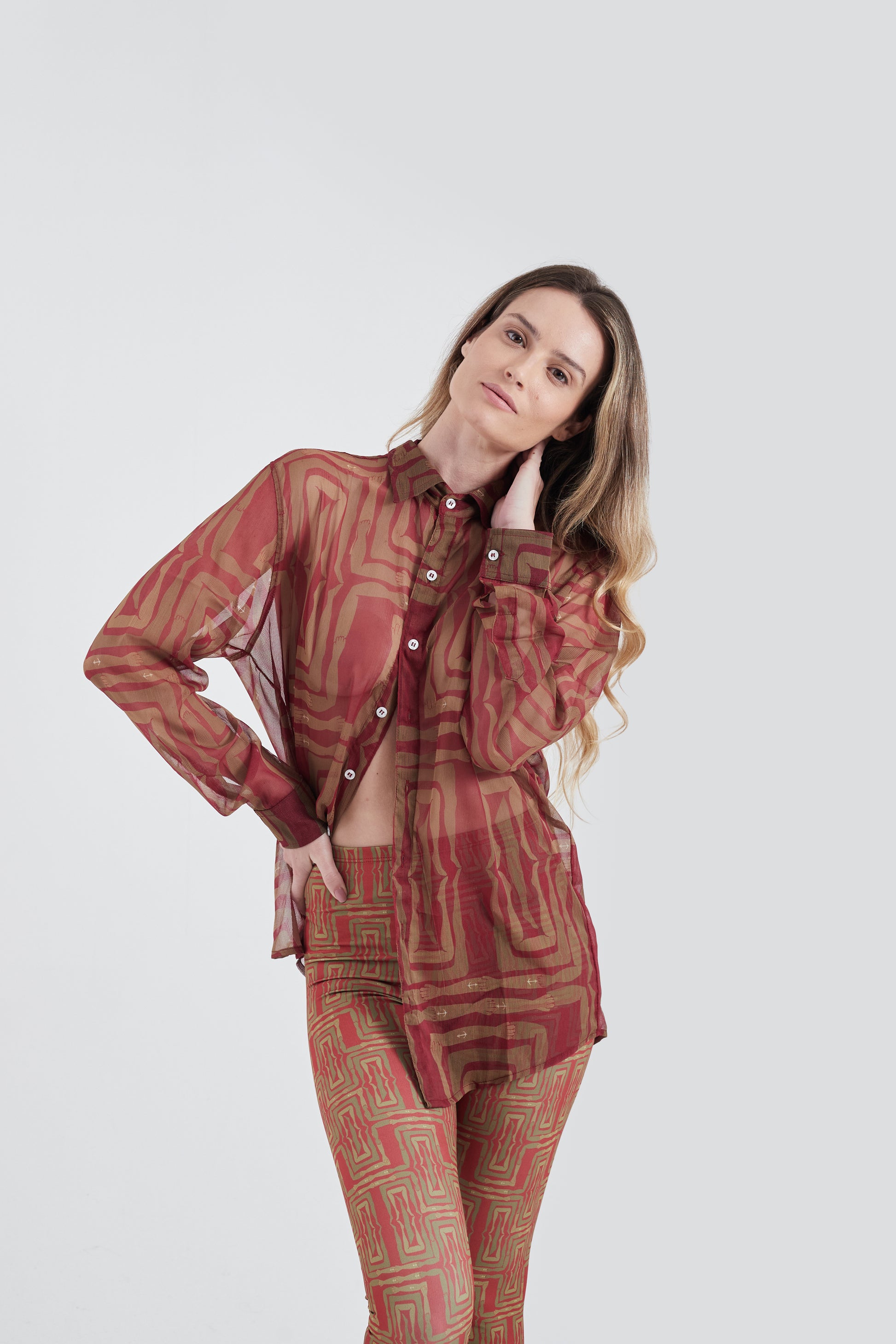 Modelo usando a Camisa Vermelho/Amarelo com estampa Mão na Perna, feita em Tule.