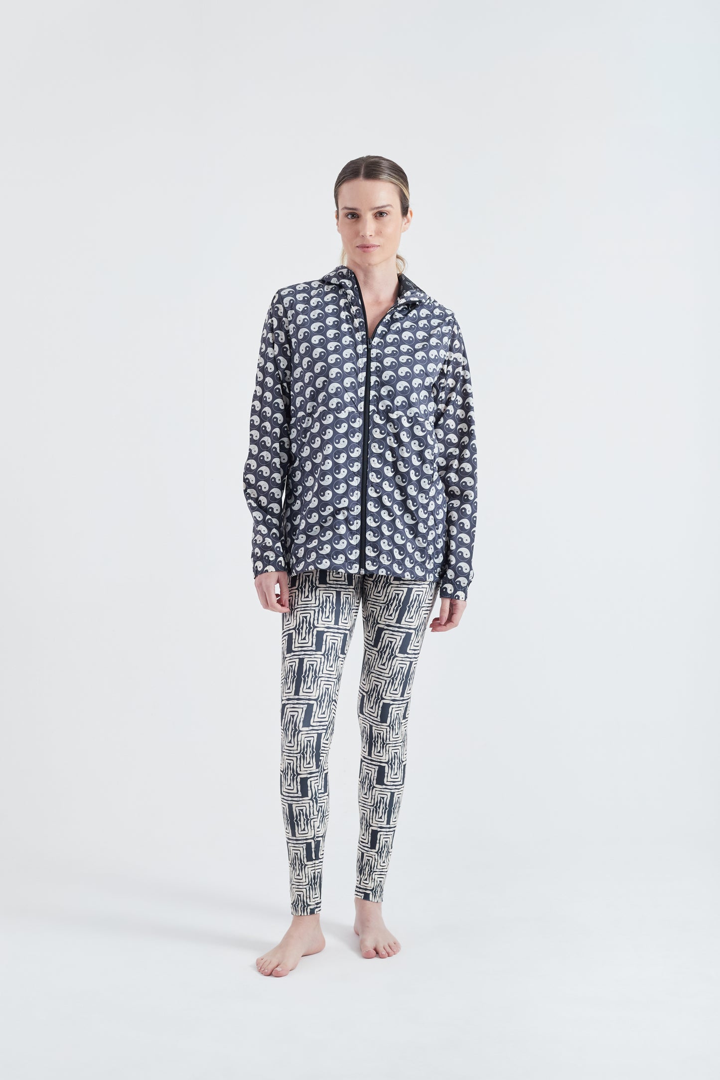 Modelo usando o corta vento unissex Yin and Out preto/branco.