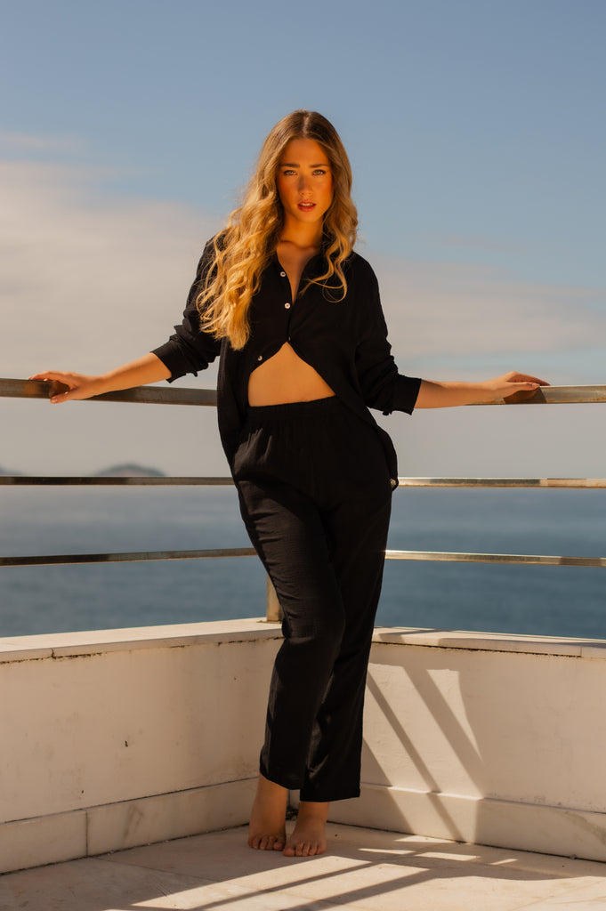 Modelo feminina vestindo full look com camisa manga longa e calça preta unissex, perfeito para um visual elegante e confortável.