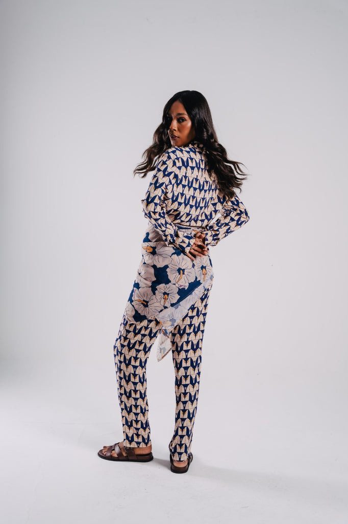 Modelo usando Full look private tile estampado, com pareo poli nation azul/off white na linha da cintura 