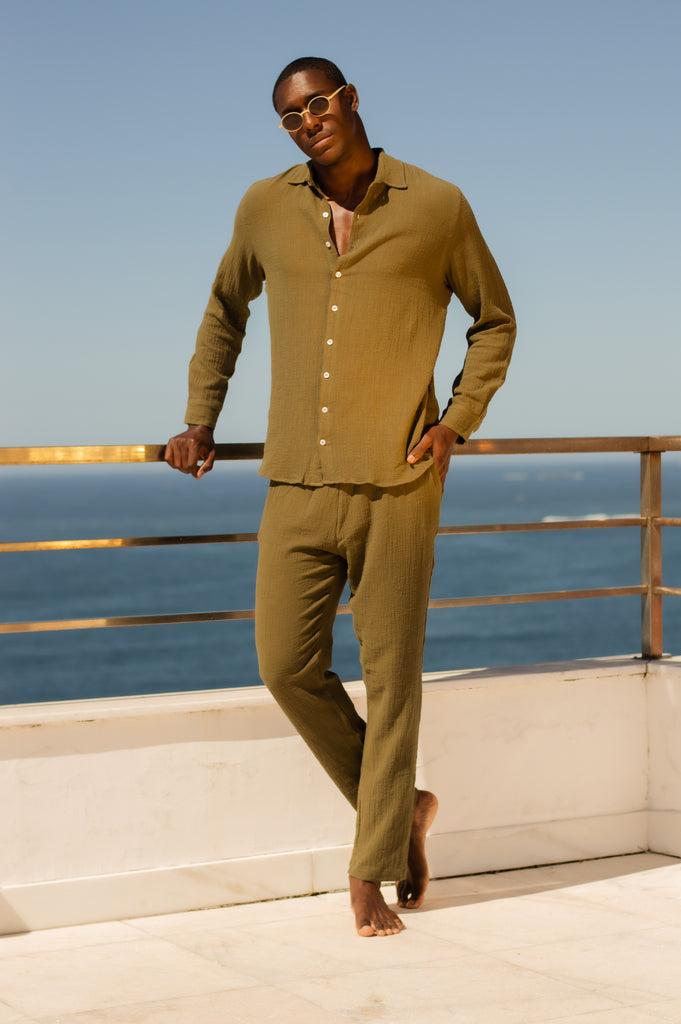 Modelo com Full Look Verde Oliva em ambiente ao ar livre, combinando elegância e descontração.