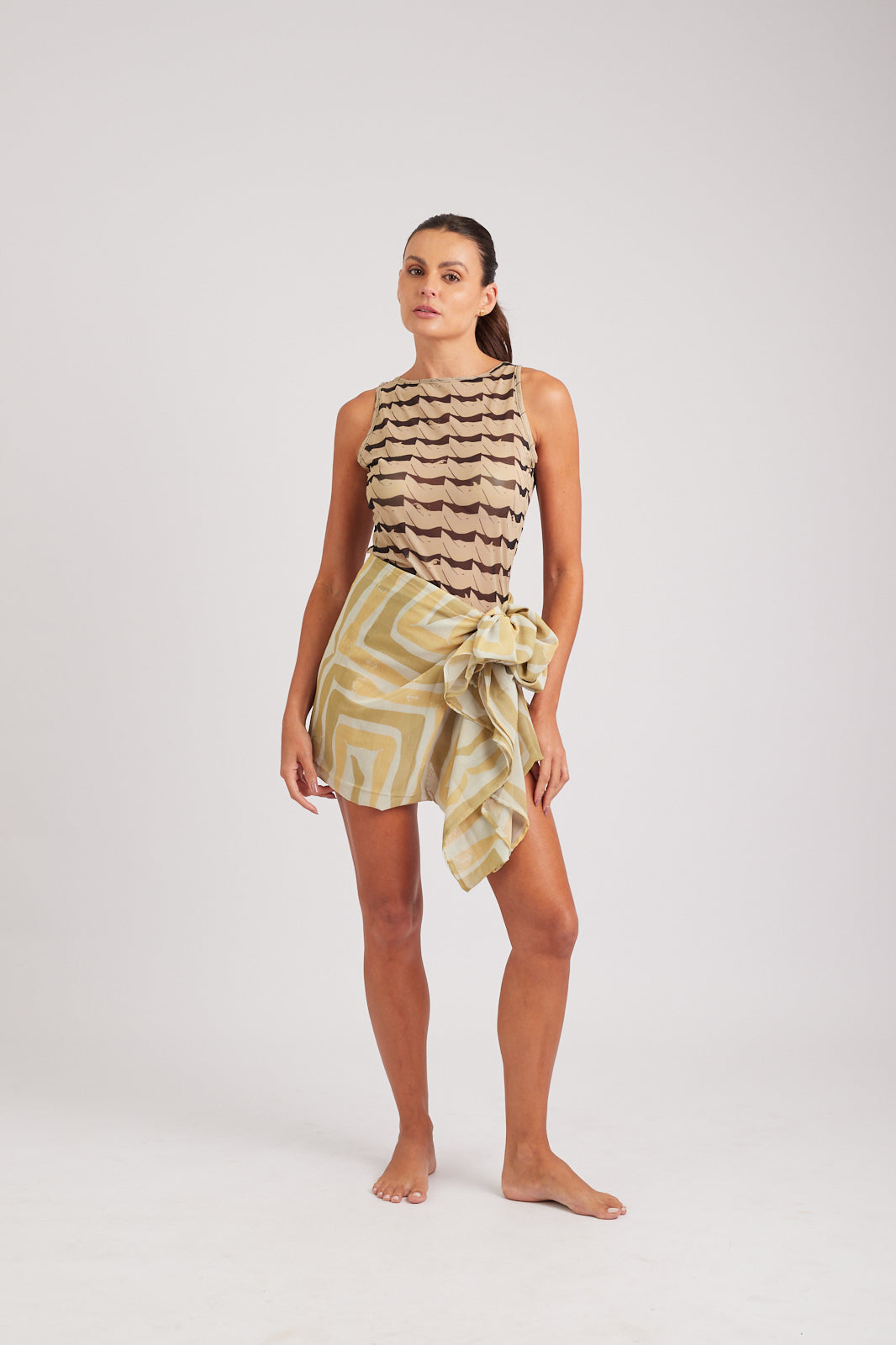 Modelo usando o pareô areia/creme Mão na Perna