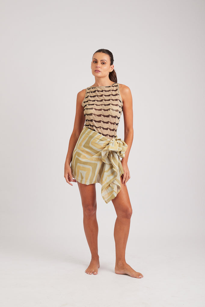 Modelo usando o pareô areia/creme Mão na Perna