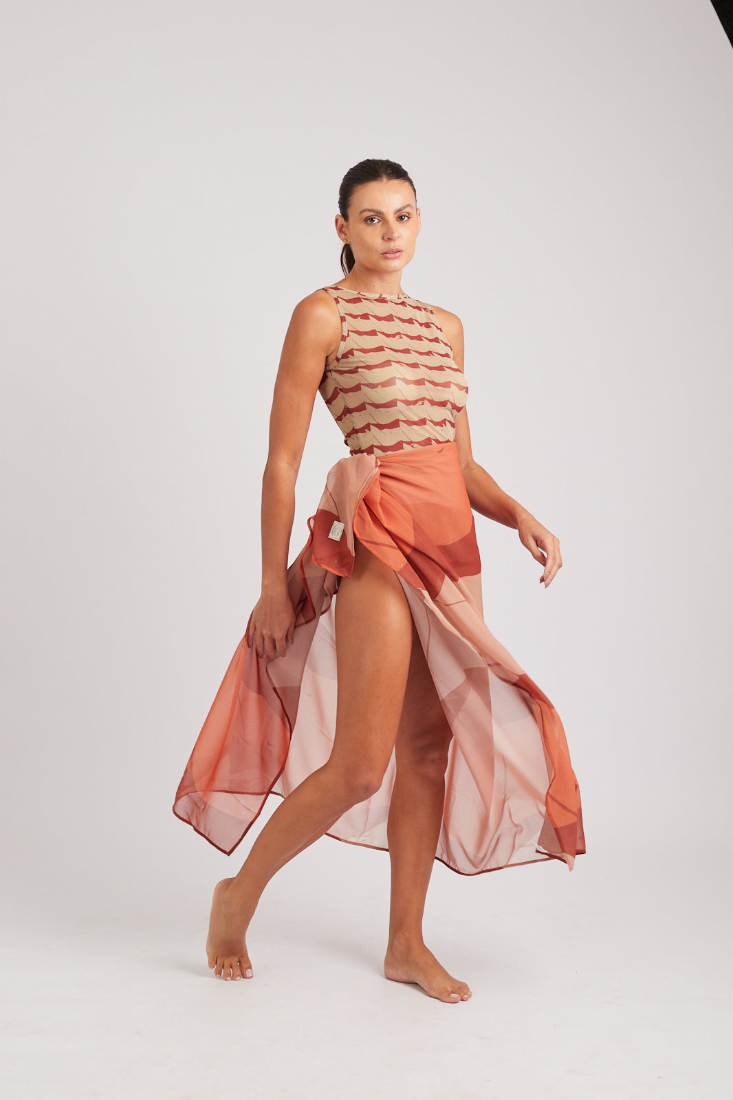 Modelo usando o pareô vermelho/creme Onda