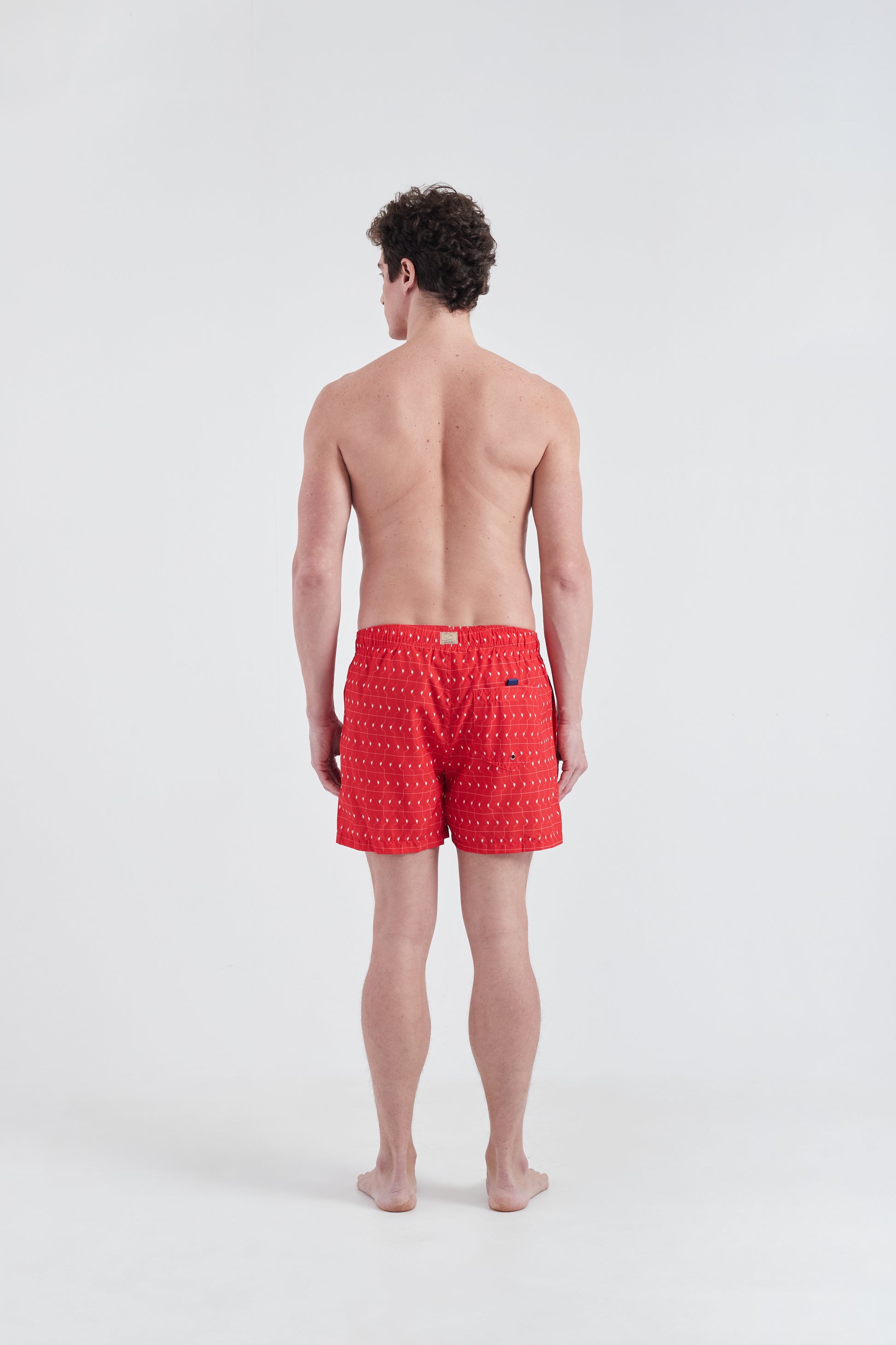 modelo com Shorts Boobie Trap, com estampa geométrica e cores vivas.