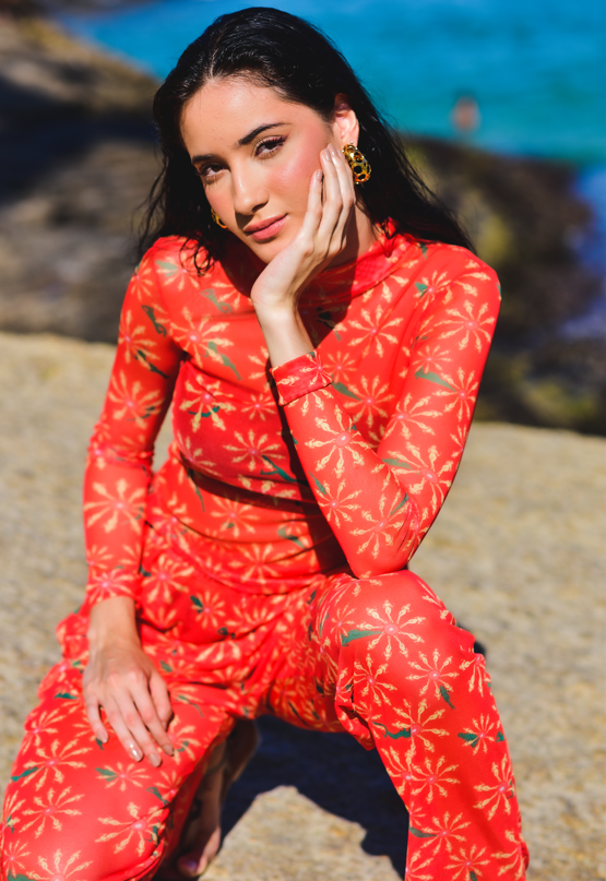 Modelo vestindo Top Flower Pau Vermelho em ambiente externo, destacando a estampa floral vibrante.