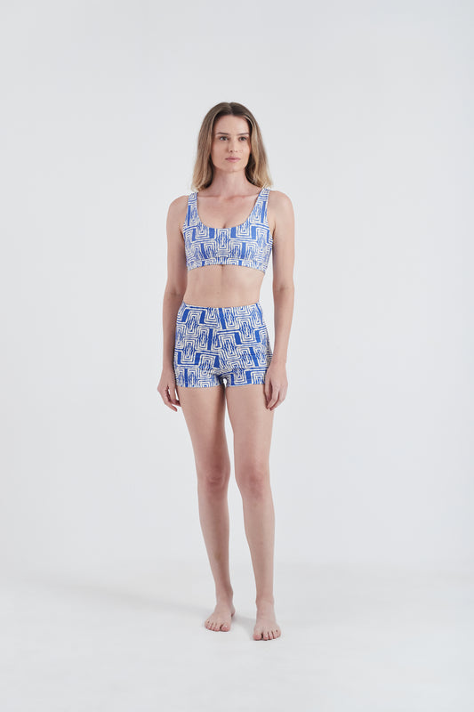 Modelo usando top + hot pants femininos azul/branco em lycra com estampa Mão Pela Perna.