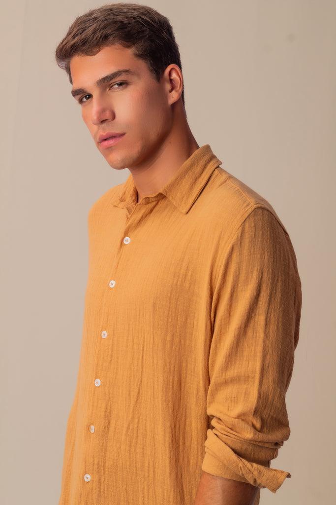 Modelo em perfil usando o Full Look Khaki, com camisa de manga longa e calça.