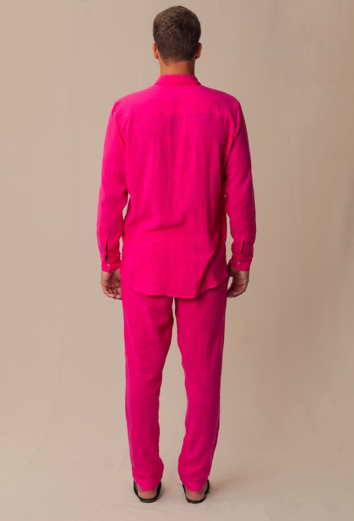 Vista traseira do full look rosa Babaloô Parioca, com camisa manga longa e calça, modelo masculino.