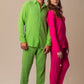 Modelos masculino e feminino usando full look rosa Babaloô e verde abacate Parioca, com camisa manga longa e calça.