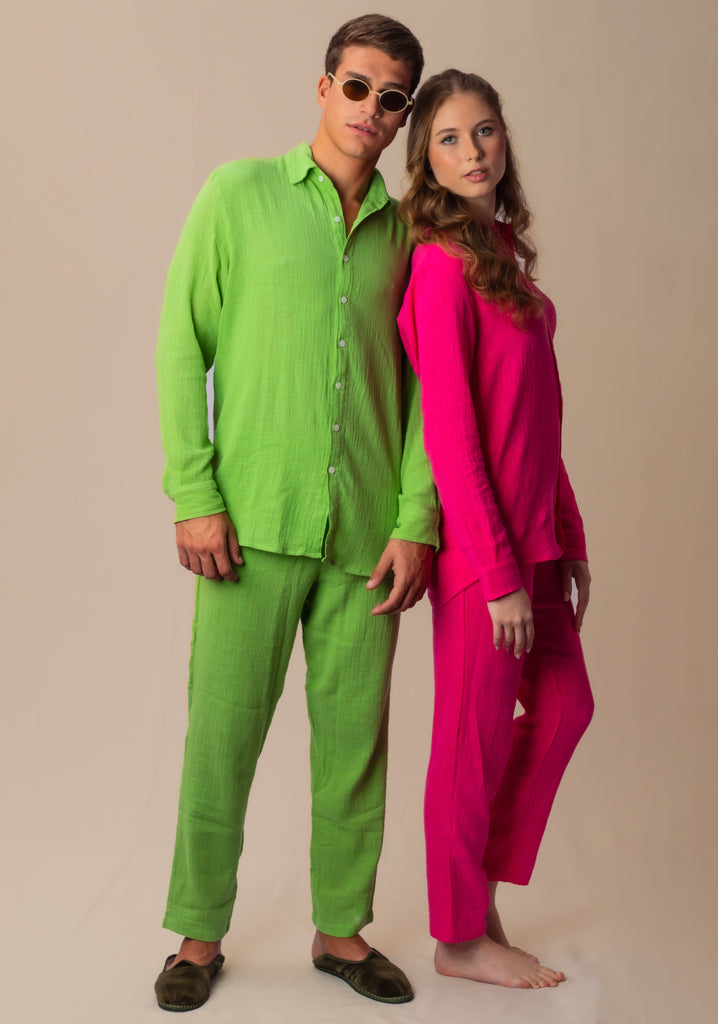 Modelos masculino e feminino usando full look rosa Babaloô e verde abacate Parioca, com camisa manga longa e calça.