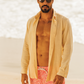 Camisa de linho areia concha combinada com shorts vermelhos, ideal para praia.
