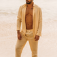 Modelo usando look completo de linho areia concha com camisa de manga longa e calça, em praia.