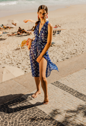 Modelo usando pareo Happy Oyster azul em cenário de praia