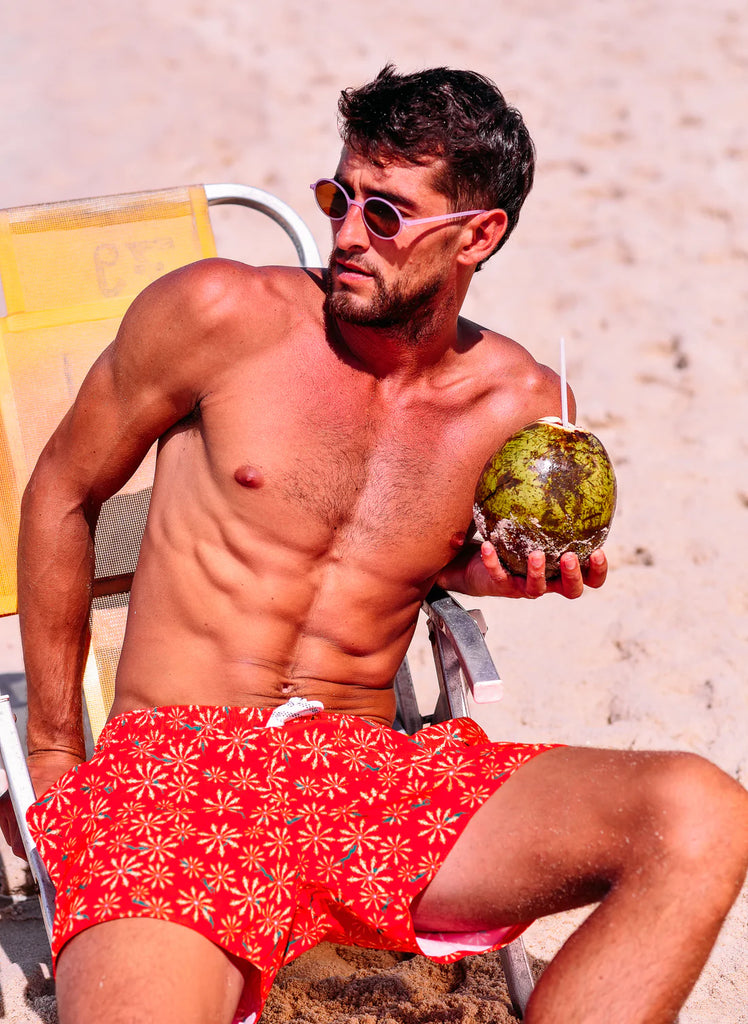 Shorts Flower Pau-Wer Vermelho apresentando estampado vermelho detalhado com amarelo com design confortável e leve. Ele possui cordão ajustavel, distribuídos uniformemente sobre um fundo claro