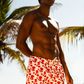 Modelo usando Shorts Happy Oyster Branco/Vermelho na praia, vista frontal, com estampa divertida e ajuste perfeito.