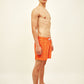 Modelo vestindo Shorts Something Fishy Laranja e Amarelo, destacando ajuste confortável e estampa vibrante.