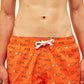 Vista frontal do modelo com Shorts Something Fishy Laranja e Amarelo, com ajuste firme e estampa divertida.