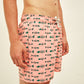 Detalhe da estampa de peixes verdes sobre fundo rosa no Shorts Something Fishy.