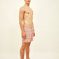 Vista lateral do modelo com Shorts Something Fishy Rosa e Verde, mostrando ajuste firme.