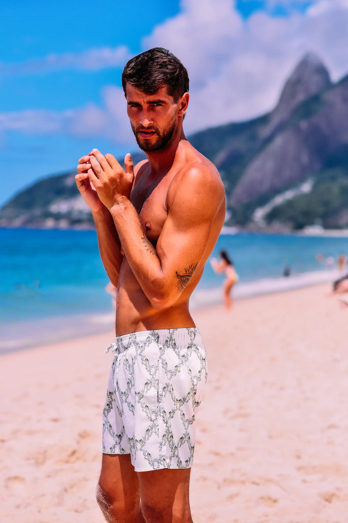 Modelo na praia usando Shorts Trepadeira Branco/Verde, com design leve e respirável.